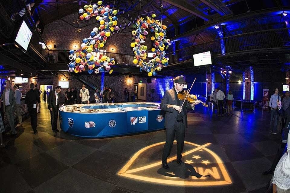 Man playing violin for a crowd at a corporate event